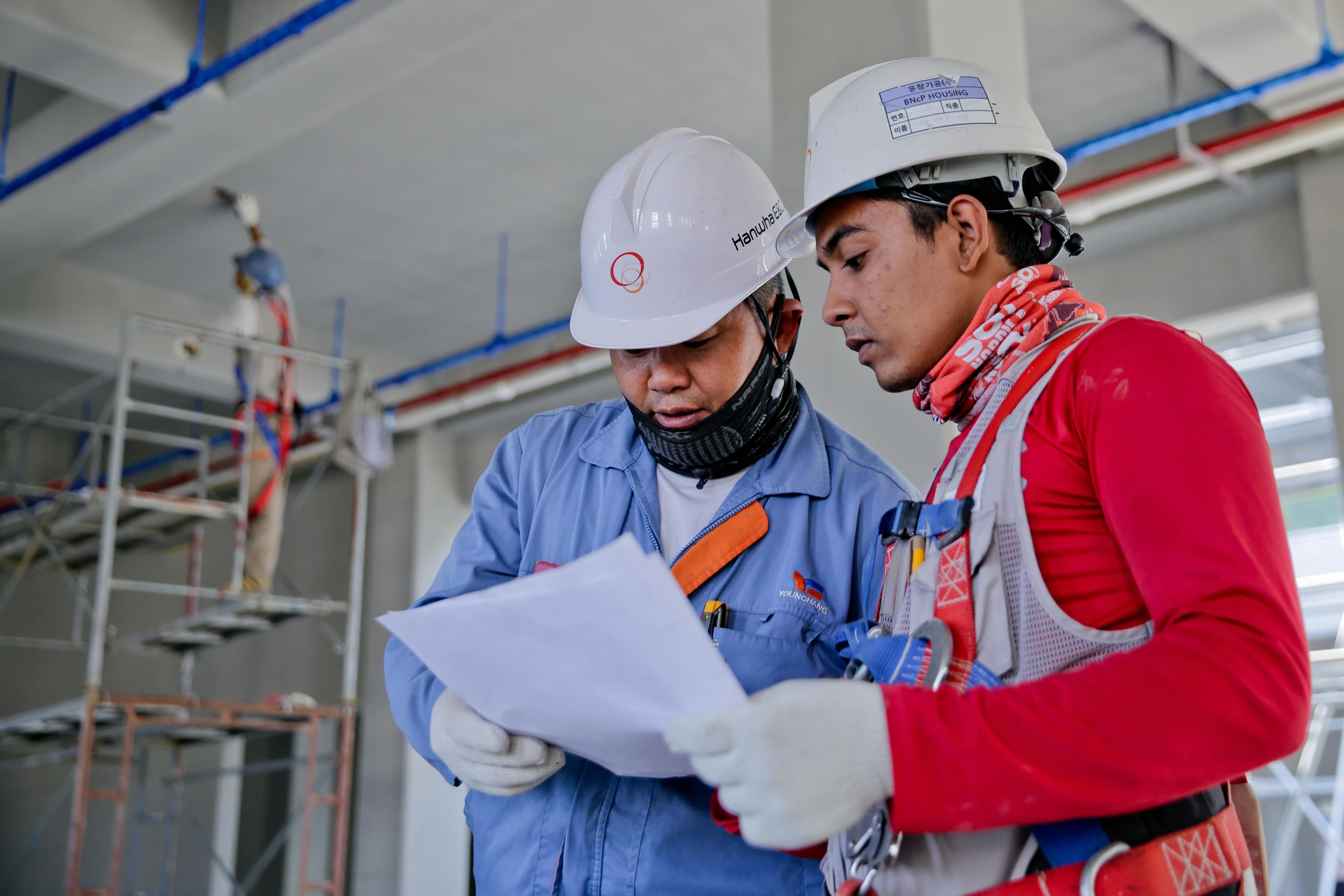 Deux ouvriers regardant un plan de construction